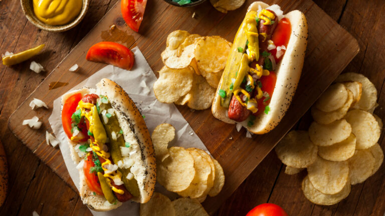 chicago style hotdogs with chips on a table for lunch